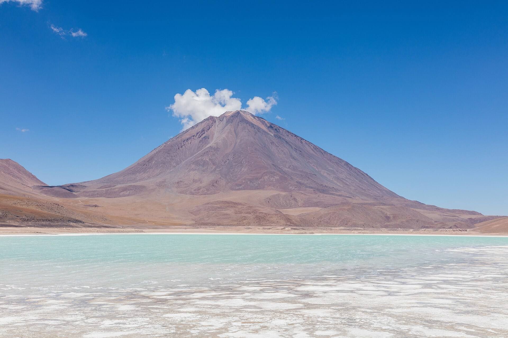 Agua verde de Laguna Verde al pie de una montaña volcánica.